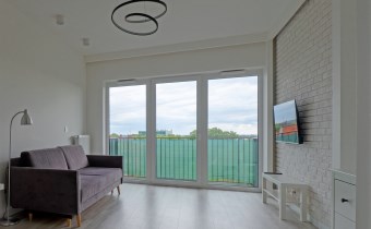 Salon z aneksem kuchennym i wyjściem na balkon